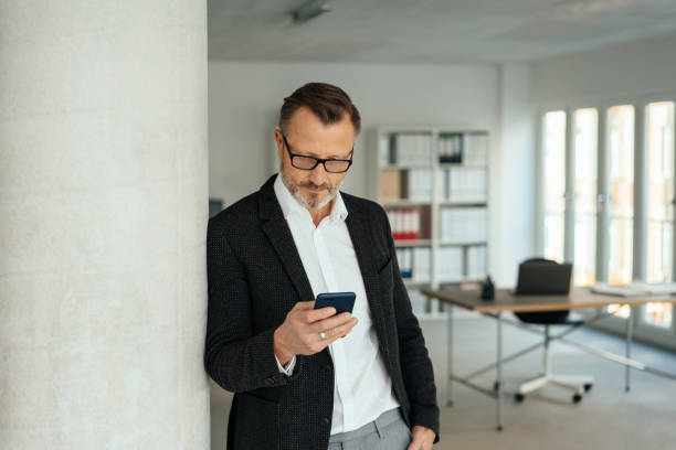 istock Stylish businessman reading a phone message 1248747150