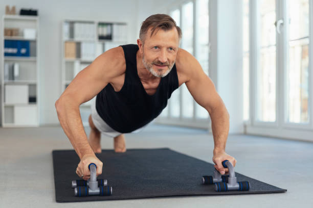 istock Middle-aged man exercising on handles for push-ups 1248748873