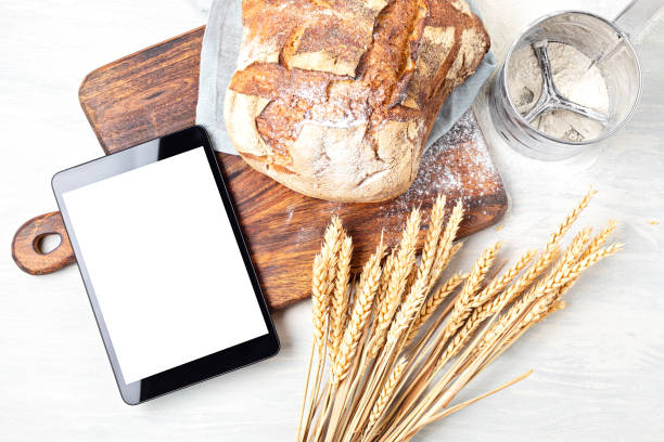 istock Fresh organic homemade bread and notepad with copy space. Healthy eating, cooking application, online bread recipes concept 1248750137