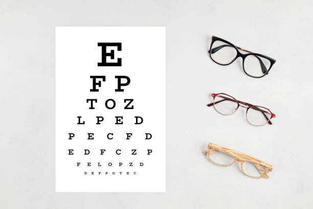 istock Collection of eyeglasses with eye test table. Optical store, glasses selection, eye test, vision examination at optician, fashion accessories concept. Top view 1248750515