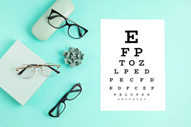 istock Collection of eyeglasses with eye test table. Optical store, glasses selection, eye test, vision examination at optician, fashion accessories concept. Top view 1248750557