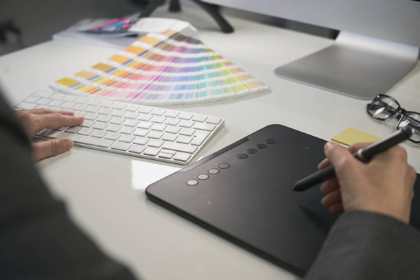 woman freelance graphic designer at work in her home office chooses colors - color swatch print color image spectrum imagens e fotografias de stock