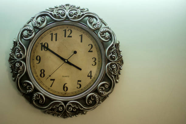 istock Ancient Wall Designer Wall Clock With Light Yellow Back Ground showing time 03.50 o'clock 1248752354