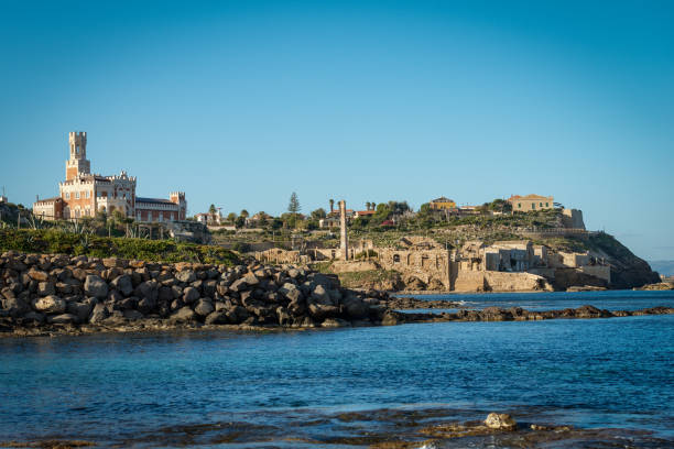 Portopalo di Capo Passero - Sicily island Italy Portopalo di Capo Passero, Sicily Island, Italy - December 8th, 2017: Coastline of Portopalo di Capo Passero village, the extreme south-east of the island of Sicily. Siracusa province, Italy, Europe. In the center, an abandoned tuna processing industry (Tonnara, italian), on the left the Tafuri Castle (Castello Tafuri, 1933), now used as a hotel. portopalo stock pictures, royalty-free photos & images