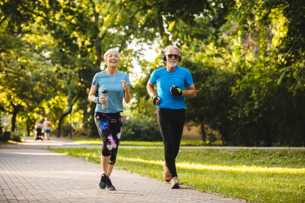 istock Senior couple jogging together in the park 1248753463