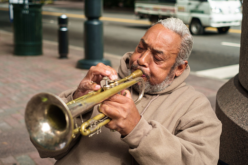 Charlotte, North Carolina - October 10, 2013:  Senior street performer playing blues style music on the trumpet in the uptown financial district.