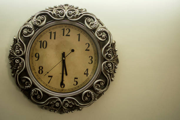 istock Ancient Wall Designer Wall Clock With Light Yellow Back Ground showing time 05.30 o'clock 1248755157