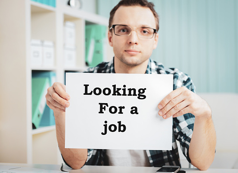 young Businessman holding a sign looking for a job