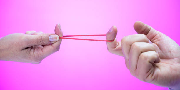 istock Two hands stretching a rubber band with their fingers 1248758304