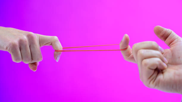 istock Two hands stretching a rubber band with their fingers 1248758332