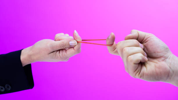 istock Two hands stretching a rubber band with their fingers 1248758357