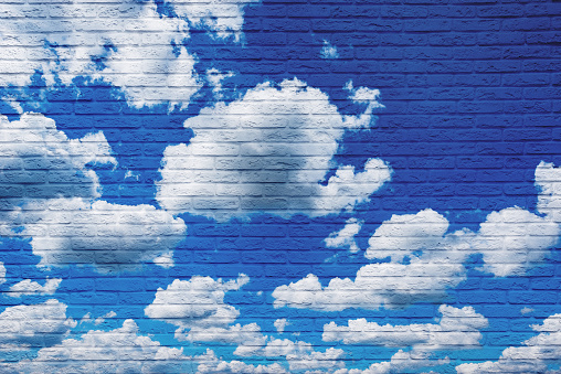 Clouds on the blue sky drawn on the brick wall.