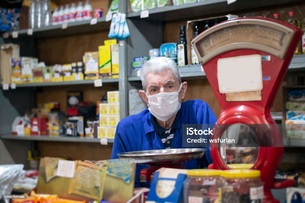 Senior Mann in seinem kleinen Lebensmittelgeschäft. Antikes Waagengewicht - Lizenzfrei Klein Stock-Foto