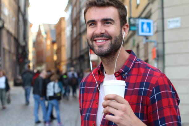 istock Handsome man holding disposable coffee cup outdoors 1248761709