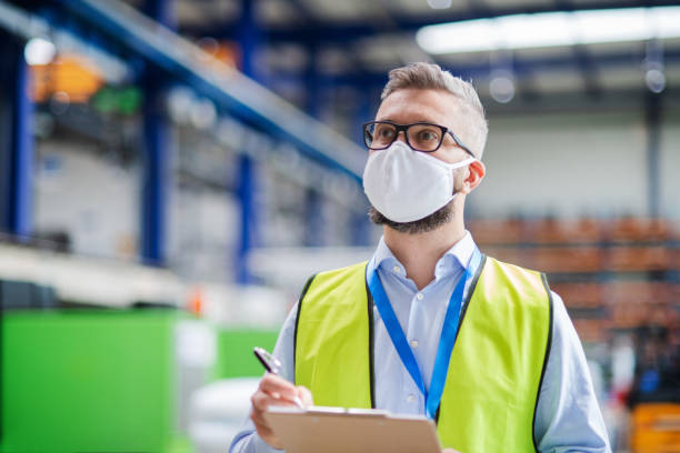 istock Technician or engineer with protective mask working in industrial factory, walking. 1248761920