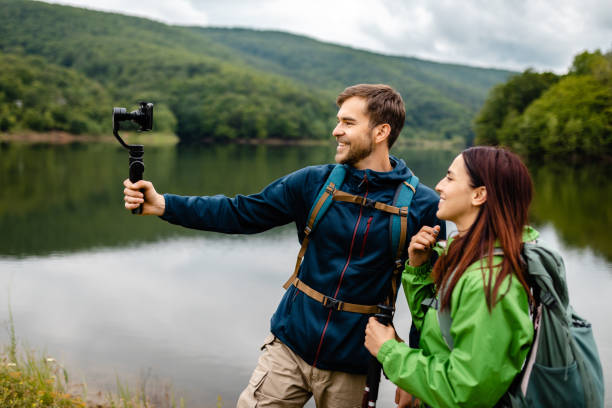 istock Excited adventurous couple sharing their experience while vlogging from a lake 1248761936