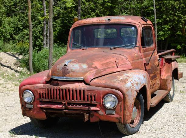 istock Old red rusty truck outdoors with trees in behind 1248762132