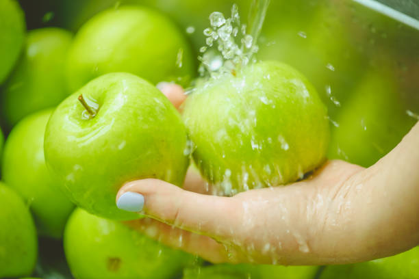 istock ripe and juicy apples,hands wash apples under running water 1248762167