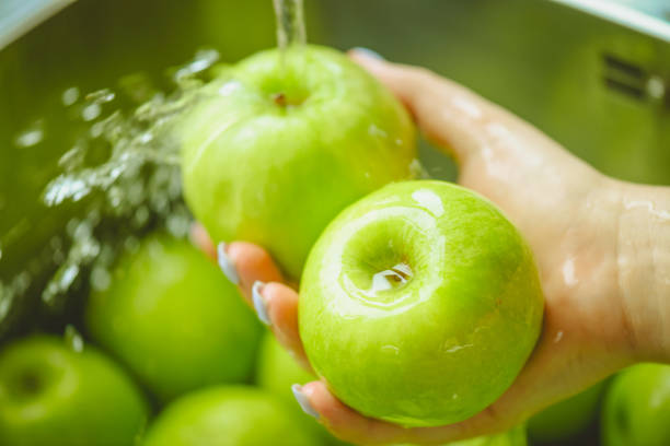 istock ripe and juicy apples,hands wash apples under running water 1248762242