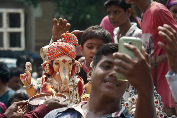 un niño se está tomando el selfie junto con la estatua del señor shree ganesha en un día de festival de ganesha. - editorial indian culture traditional culture horizontal fotografías e imágenes de stock