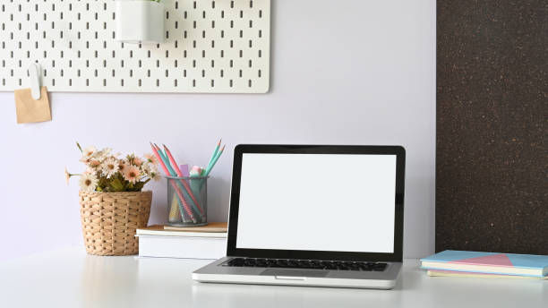 istock A white blank screen laptop is putting on a white working desk surrounded by office equipment. 1248763864