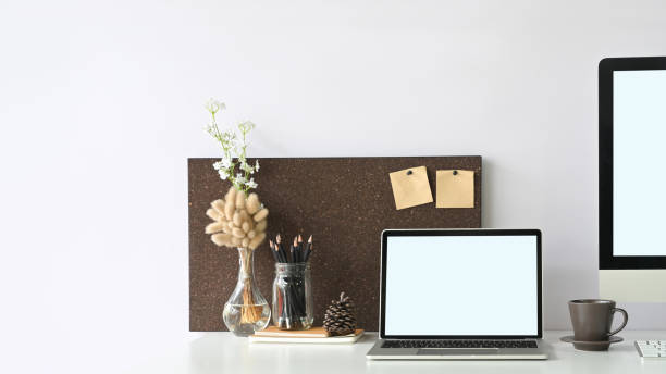istock A white blank screen laptop is putting on a white working desk surrounded by office equipment. 1248763932