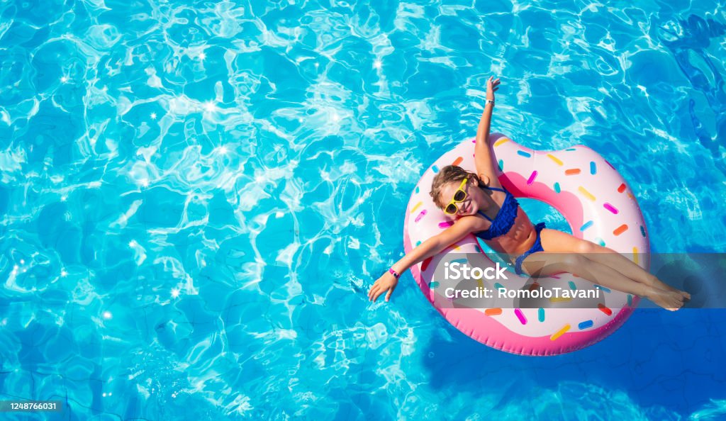 Funny Child On Inflatable Donut In Pool Funny Little Girl Playing On Inflatable Donut In Pool Swimming Pool Stock Photo