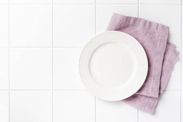 istock White plate, cutlery and napkin on stone table top view. Table setting. 1248767066