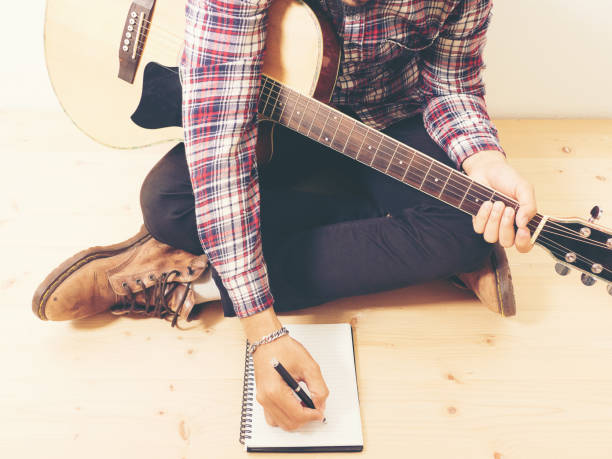 istock Young hipster composing the song with guitar . 1248767803