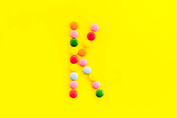 istock Letter K - alphabet made with sweets on yellow from above 1248767804