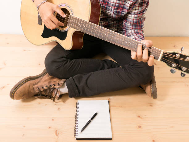 istock Young hipster composing the song with guitar . 1248767818