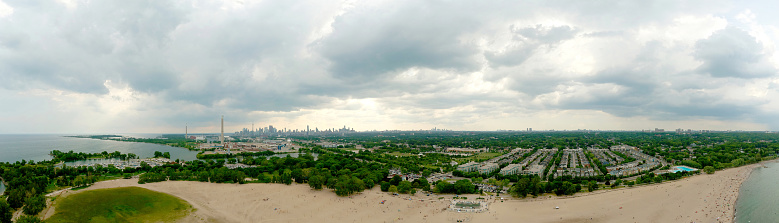 Toronto Woodbine Beach and sandy beach with people swimming, aerial view, Ontario, Canada, rainy cloudy greenery coast with boats at summer. Many residential houses. Popular tourist location