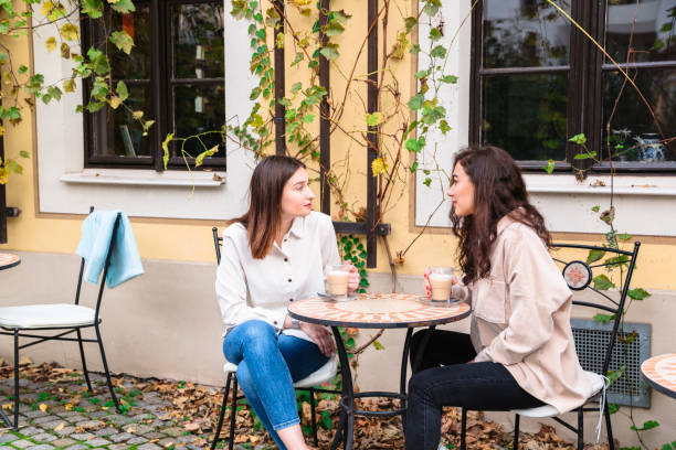 istock Two young women talk and drink coffee in cafe 1248768882