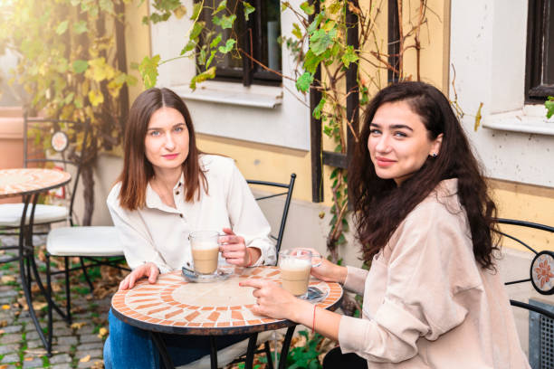 istock Two women drink coffee in cafe and pose for camera 1248768894