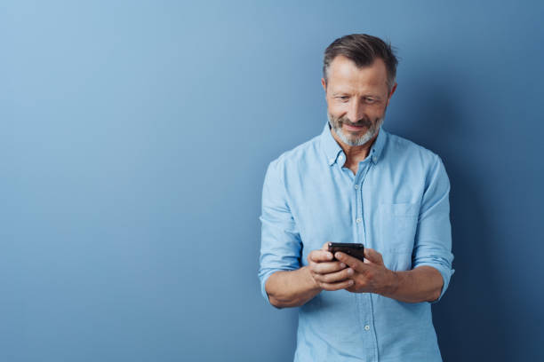 istock Middle-aged man reading an sms on his mobile 1248769661