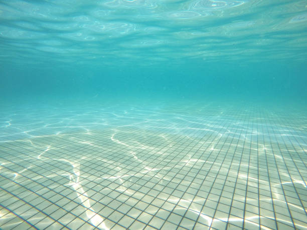 istock Underwater View Of Swimming Pool Floor With Sunlight Reflections. 1248770420