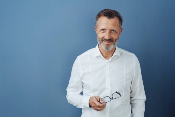 istock Friendly relaxed middle-aged man holding glasses 1248770576