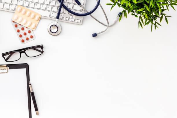 istock Doctor desk with pills, tablet, stethoscope. White table top-down space for text 1248771004
