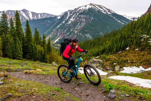 female mountain biker rides along mountain ridge - mountain biking colorado action cycling imagens e fotografias de stock