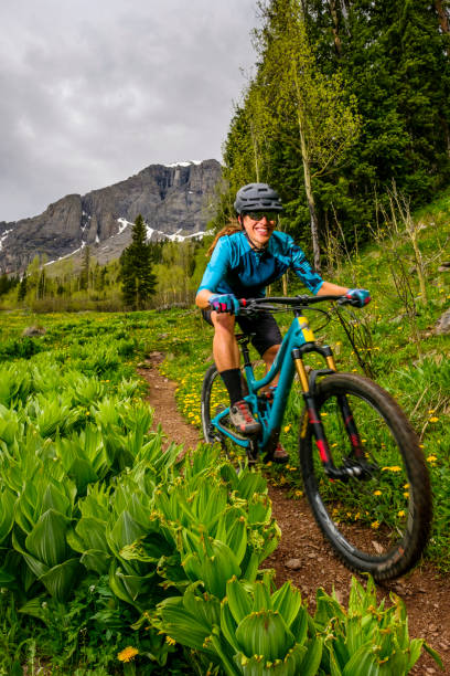 istock Female mountain biker rides along forested path 1248774143