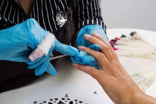 istock Nail salon, hands of master and client, processing nails with manicure scissors 1248774160