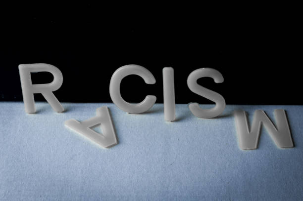 Drop racism, word written with letters on a two-tone background, the second and last letter fell. Concept against racism.