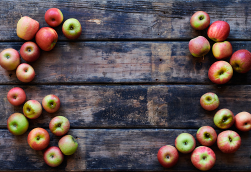 Wooden Surface with various apple varietals border with copy space