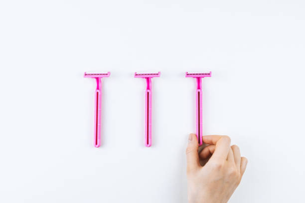 istock Female hand takes pink disposable razor. 1248776014