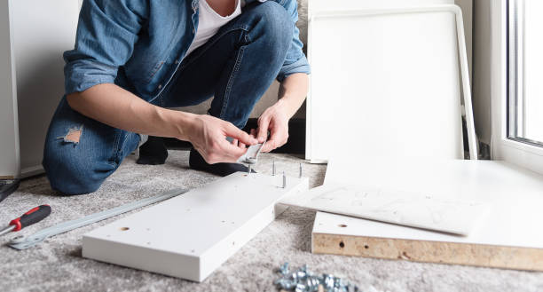 istock Concentrated young man assembling new furniture for home 1248776137