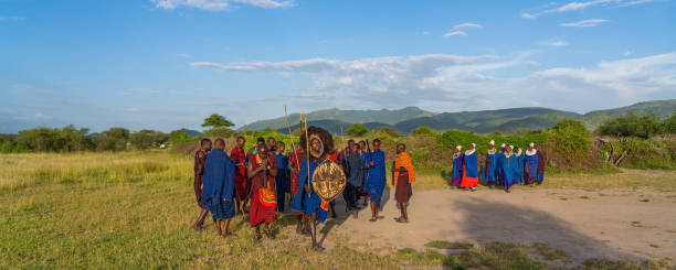 красивая панорама выстрел из группы массай человек участвует традиционный танец воина во время заката - ceremonial dancing стоковые фото и изображения