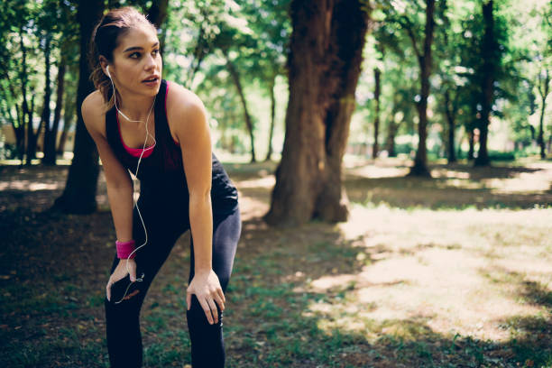 istock Young attractive female runner taking a break from running in nature. 1248778053