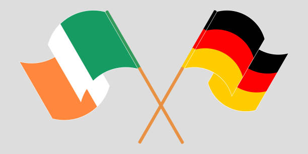 gekreuzte und schwenkende flaggen irlands und deutschlands - irish culture republic of ireland irish flag sport stock-grafiken, -clipart, -cartoons und -symbole