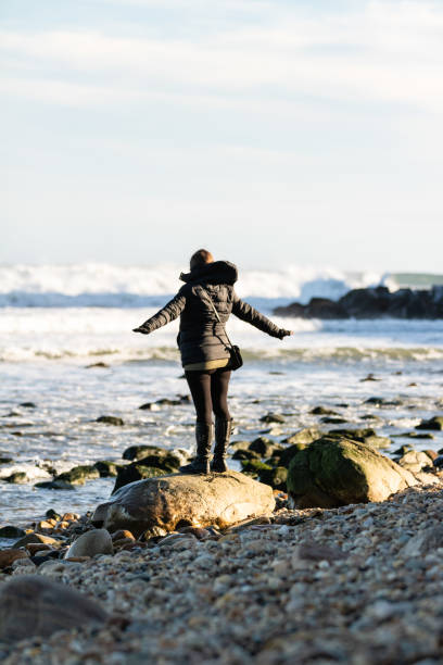 岩の上に立つ若い女性, 海を見てビーチでポーズ. - free your mind 写真 ストックフォトと画像