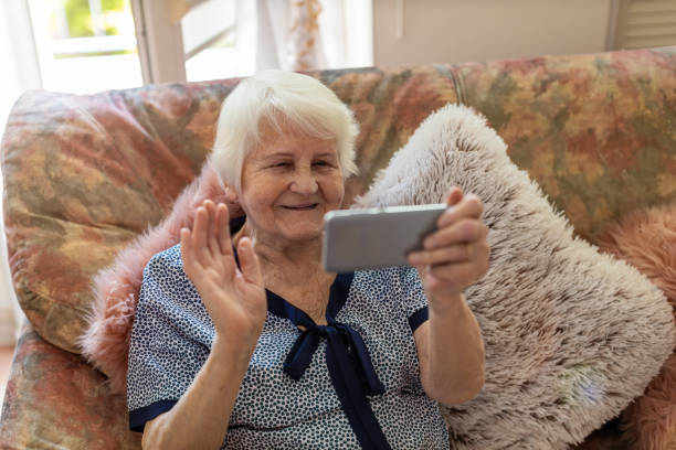 istock Senior woman using mobile phone at home 1248780058